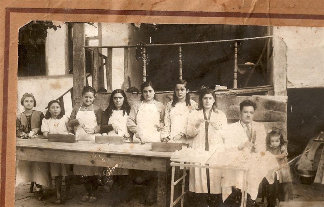 Uzun bir masanın başında dizilmiş, beyaz önlüklü kadınlar ve kız çocukları